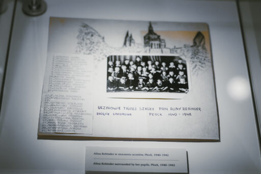 Galeria płocczan XX wieku. Papierowa tabliczka ze zdjęciem dzieci uczestniczących w tajnym kompletach w czasie drugiej wojny światowej w Płocku. Obok wypisana ręcznie lista ich naziwsk.